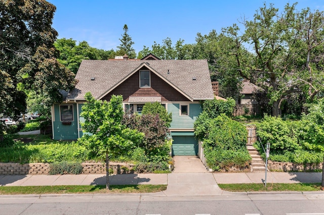 3553 Dupont Ave S, Minneapolis, MN 55408 - view of front of house featuring a shingled roof, a garage, driveway, and stairway