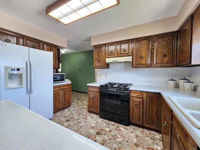 25 3rd Ave NE, Plainview, MN 55964 - kitchen featuring white fridge with ice dispenser, black range with gas cooktop, stainless steel microwave, under cabinet range hood, and light countertops