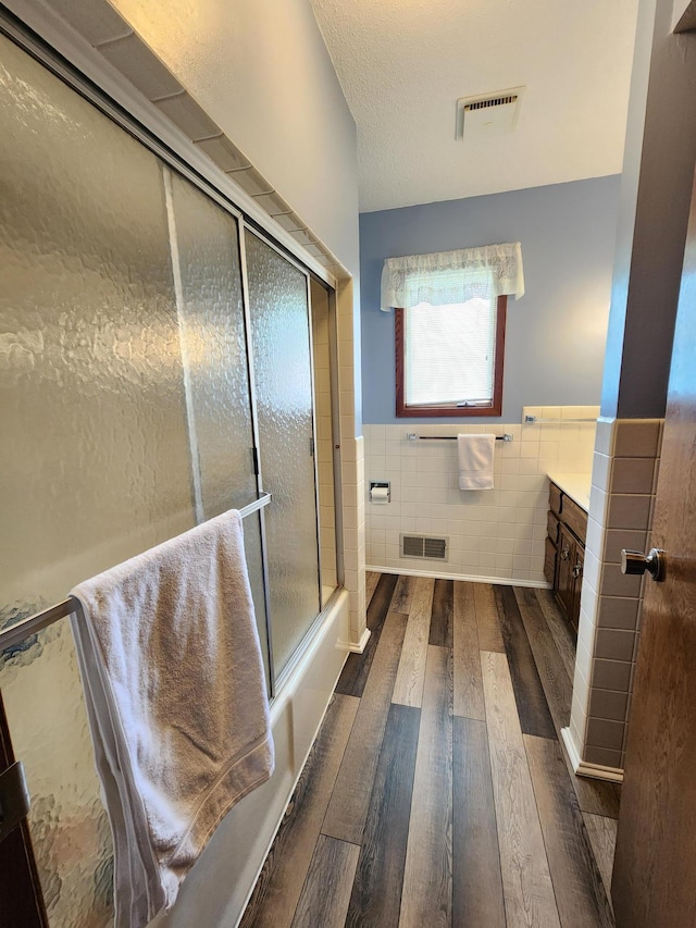 25 3rd Ave NE, Plainview, MN 55964 - full bathroom featuring tile walls, hardwood / wood-style flooring, vanity, and wainscoting