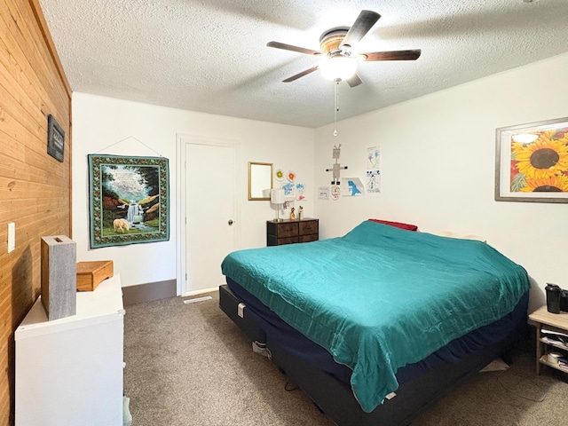 20 1st St, Luck, WI 54853 - carpeted bedroom with wooden walls, a textured ceiling, and a ceiling fan