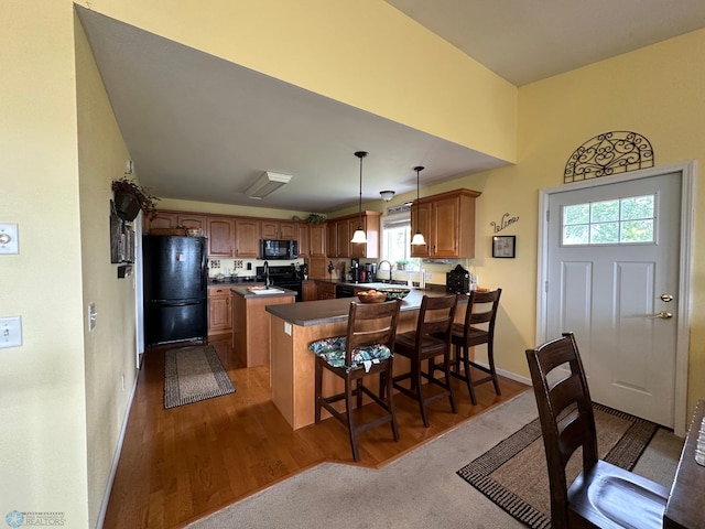 44556 Mcgowan Estates Rd, Rush Lake Twp, MN 56571 - kitchen with black appliances, a peninsula, a sink, dark countertops, and wood finished floors