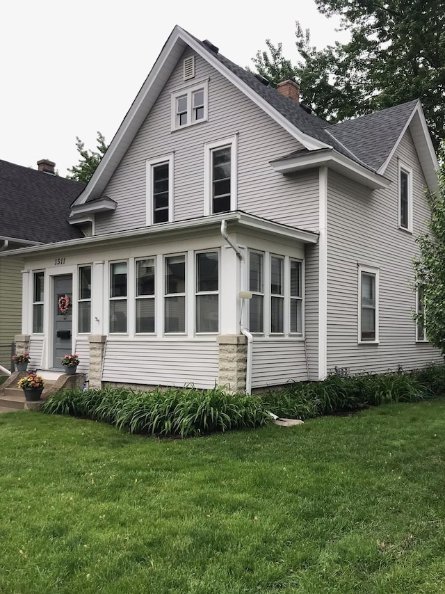 1311 Monroe St NE, Minneapolis, MN 55413 - view of front facade with a chimney, a front yard, and a shingled roof