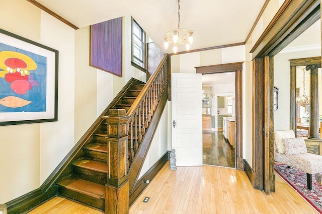 1311 Monroe St NE, Minneapolis, MN 55413 - stairs with hardwood / wood-style floors, a chandelier, ornamental molding, and baseboards