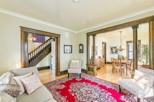 1311 Monroe St NE, Minneapolis, MN 55413 - living room featuring wood finished floors, a chandelier, ornamental molding, stairs, and decorative columns