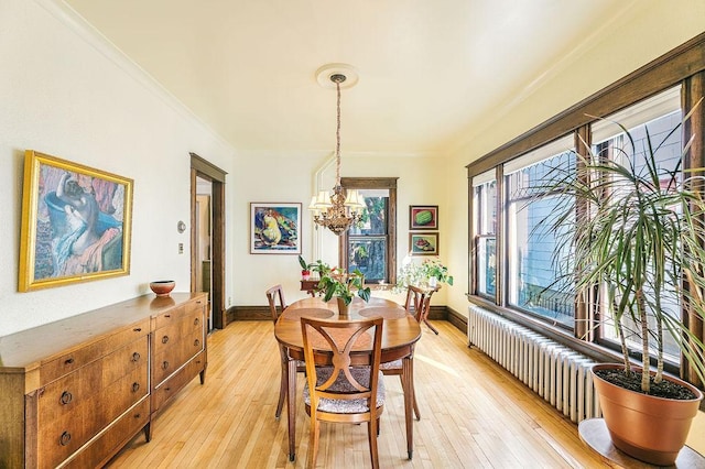 1311 Monroe St NE, Minneapolis, MN 55413 - dining area featuring crown molding, light wood-type flooring, radiator, a chandelier, and baseboards