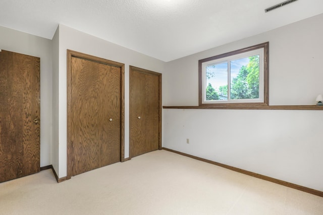 1432 11th Ave N, Saint Cloud, MN 56303 - unfurnished bedroom with two closets, light colored carpet, and baseboards