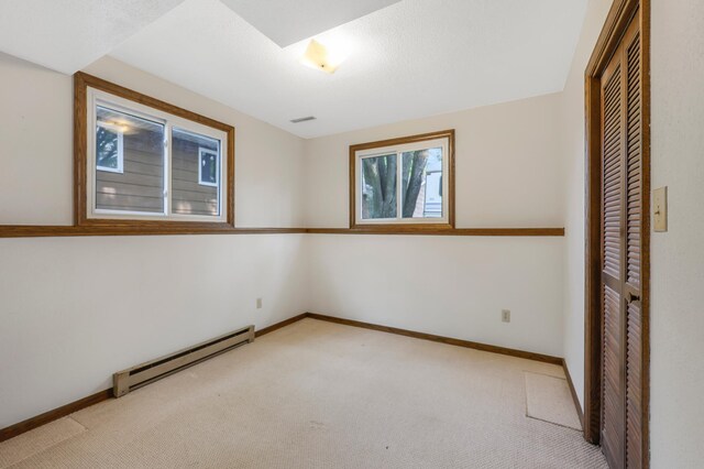 1432 11th Ave N, Saint Cloud, MN 56303 - unfurnished bedroom with baseboard heating, light colored carpet, a closet, and baseboards