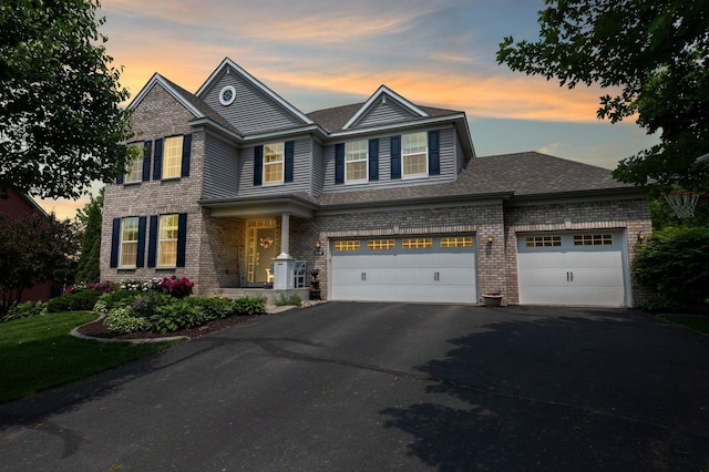 8607 Portage Ln E, Shakopee, MN 55379 - view of front facade featuring driveway, brick siding, and a shingled roof