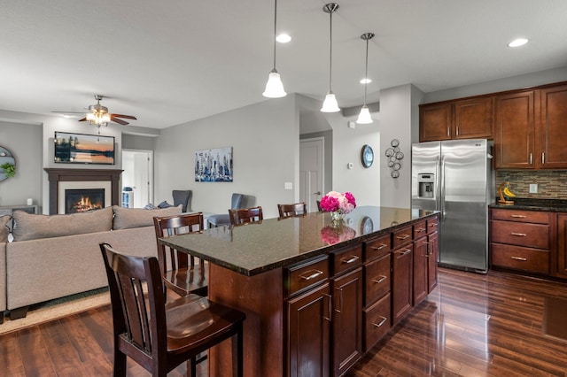8607 Portage Ln E, Shakopee, MN 55379 - kitchen featuring stainless steel fridge with ice dispenser, a breakfast bar area, dark wood-style flooring, open floor plan, and recessed lighting