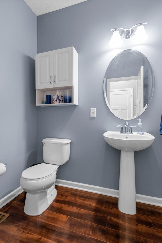 8607 Portage Ln E, Shakopee, MN 55379 - half bathroom featuring wood finished floors, toilet, and baseboards