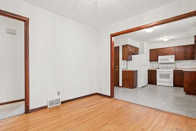 5421 Church Rd, Mound, MN 55364 - kitchen featuring white appliances, light countertops, baseboards, light wood-style flooring, and dark brown cabinets