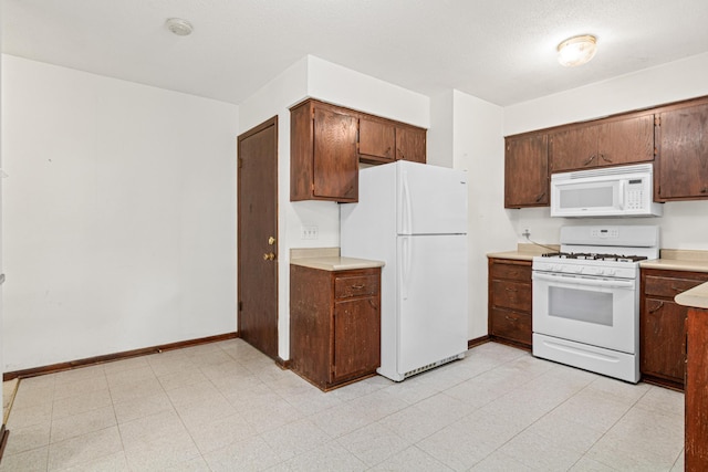 5421 Church Rd, Mound, MN 55364 - kitchen featuring white appliances, light countertops, baseboards, and light floors
