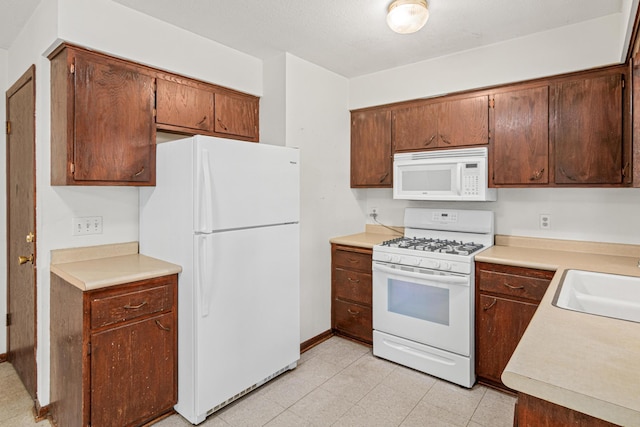 5421 Church Rd, Mound, MN 55364 - kitchen featuring white appliances, light countertops, a sink, and baseboards