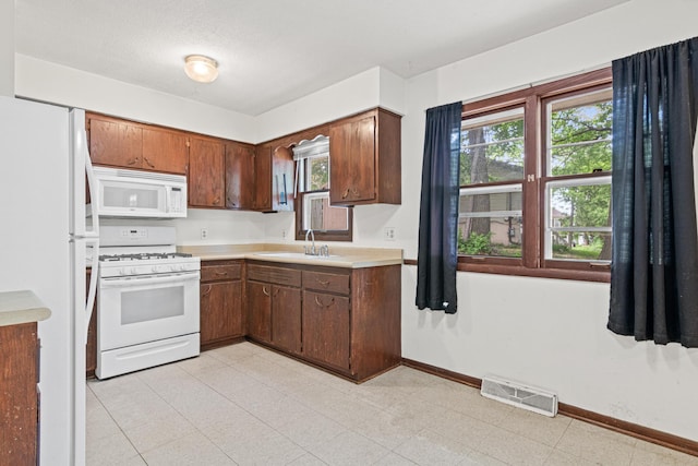 5421 Church Rd, Mound, MN 55364 - kitchen with white appliances, a sink, light countertops, and baseboards