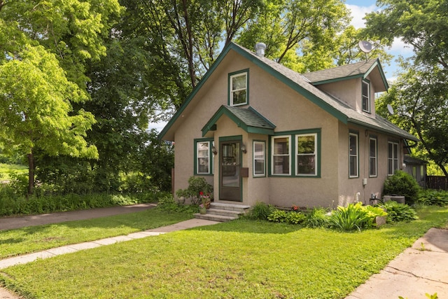 246 Griggs St S, Saint Paul, MN 55105 - bungalow featuring stucco siding, a front yard, and roof with shingles