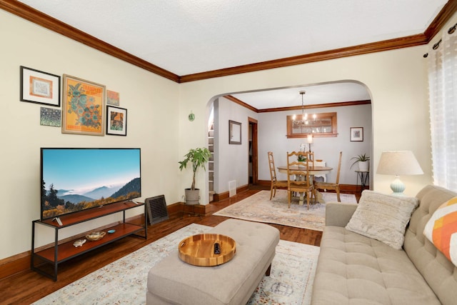 246 Griggs St S, Saint Paul, MN 55105 - living room featuring arched walkways, wood finished floors, ornamental molding, and a chandelier