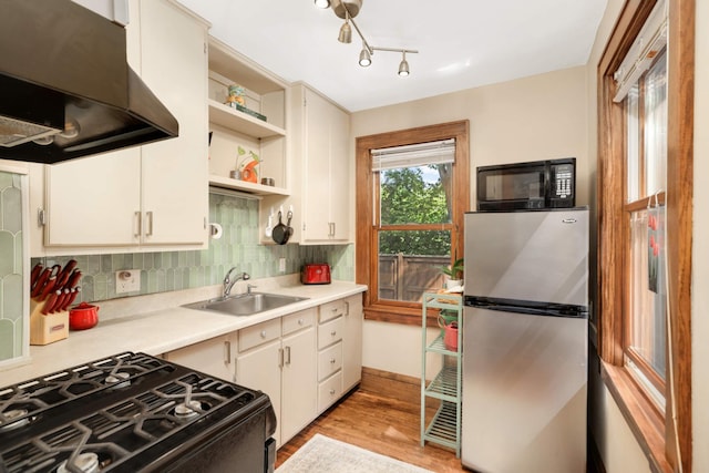 246 Griggs St S, Saint Paul, MN 55105 - kitchen featuring black appliances, range hood, light countertops, open shelves, and light wood-style floors