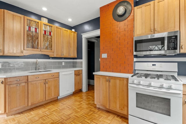 2441 Grand Ave S, Minneapolis, MN 55405 - kitchen featuring white appliances, a sink, light countertops, recessed lighting, and glass insert cabinets