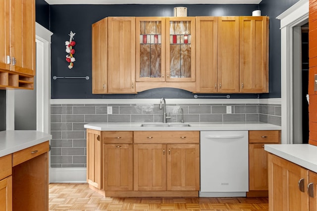 2441 Grand Ave S, Minneapolis, MN 55405 - kitchen with white dishwasher, a sink, light countertops, and glass insert cabinets