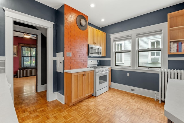 2441 Grand Ave S, Minneapolis, MN 55405 - kitchen featuring white gas range oven, stainless steel microwave, radiator, light countertops, and recessed lighting