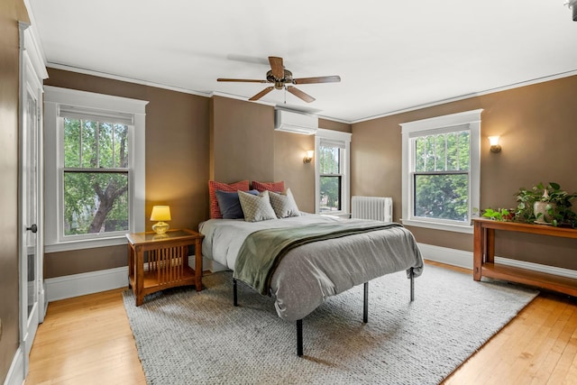 2441 Grand Ave S, Minneapolis, MN 55405 - bedroom featuring radiator, light wood-style flooring, multiple windows, ornamental molding, and baseboards