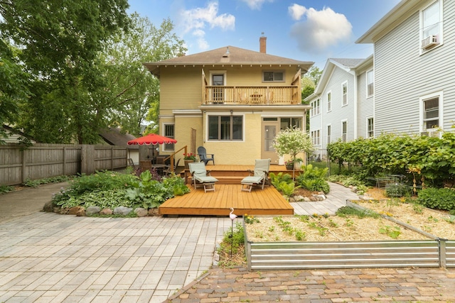 2441 Grand Ave S, Minneapolis, MN 55405 - rear view of property featuring a balcony, a fenced backyard, a chimney, a wooden deck, and a patio