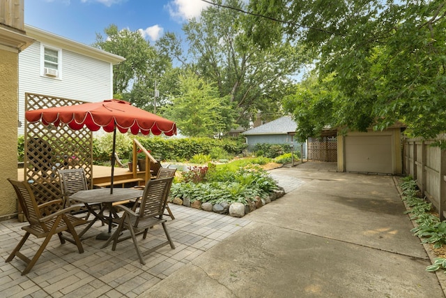 2441 Grand Ave S, Minneapolis, MN 55405 - view of patio / terrace with outdoor dining area, concrete driveway, and an outbuilding