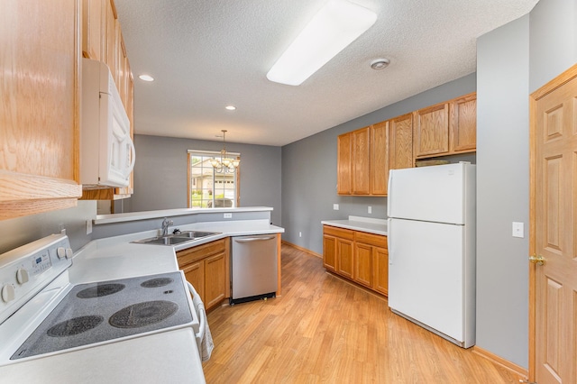 13049 Europa Trail Way N Unit H, Hugo, MN 55038 - kitchen featuring white appliances, light wood-style flooring, a peninsula, a chandelier, and a textured ceiling