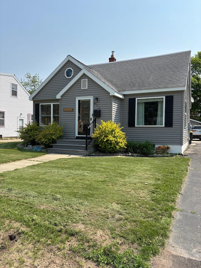 613 13th St SW, Willmar, MN 56201 - bungalow-style home with roof with shingles, a front yard, and a chimney