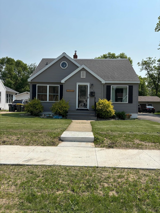 613 13th St SW, Willmar, MN 56201 - bungalow featuring a front yard, roof with shingles, and a chimney