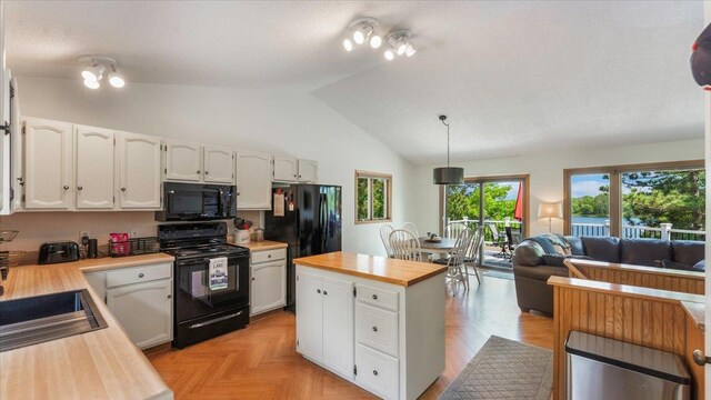 13956 Hardy Lake Rd SW, Pillager, MN 56473 - kitchen with black appliances, butcher block counters, white cabinetry, lofted ceiling, and open floor plan