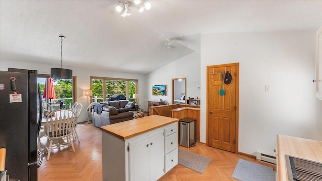 13956 Hardy Lake Rd SW, Pillager, MN 56473 - kitchen featuring freestanding refrigerator, lofted ceiling, white cabinets, a baseboard radiator, and butcher block counters