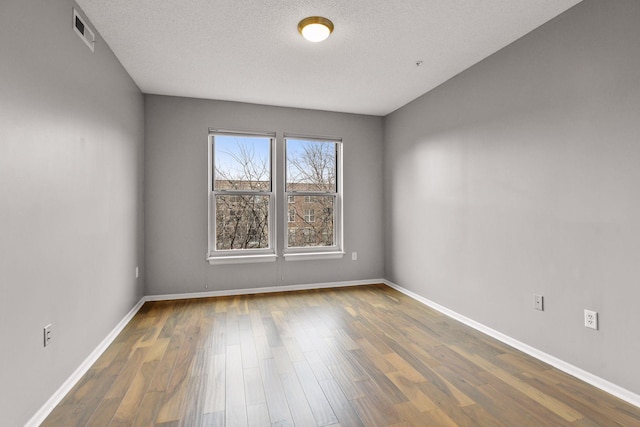 560 2nd St Unit 302, Minneapolis, MN 55401 - empty room featuring wood finished floors, baseboards, and a textured ceiling