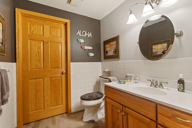 4910 Upper 148th Ct, Apple Valley, MN 55124 - bathroom featuring tile walls, vanity, a wainscoted wall, wood finished floors, and a textured ceiling
