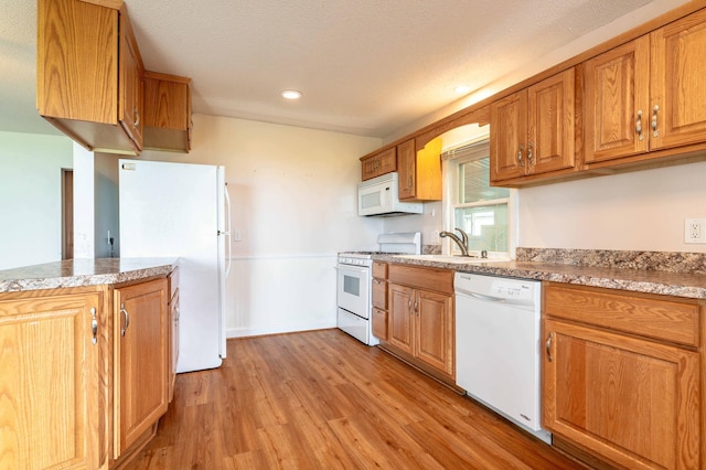 27326 Cloverleaf Ln, Everts Twp, MN 56515 - kitchen with white appliances, light wood finished floors, a sink, brown cabinets, and recessed lighting