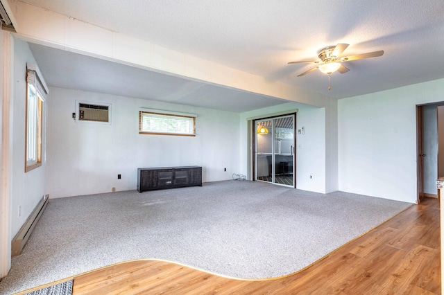 27326 Cloverleaf Ln, Everts Twp, MN 56515 - unfurnished living room featuring a baseboard radiator, ceiling fan, wood finished floors, a wall unit AC, and carpet
