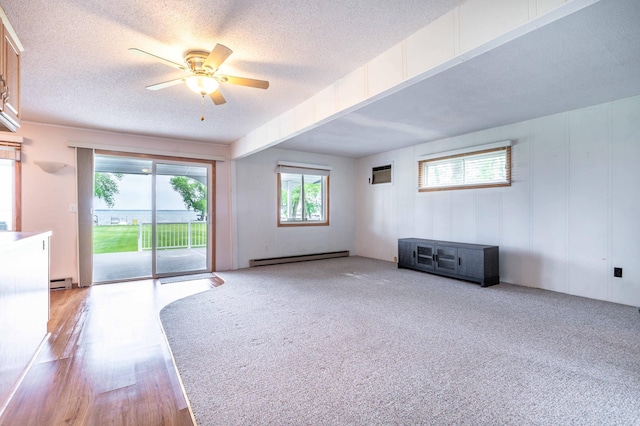 27326 Cloverleaf Ln, Everts Twp, MN 56515 - unfurnished living room featuring a ceiling fan, baseboard heating, a textured ceiling, and a wall unit AC