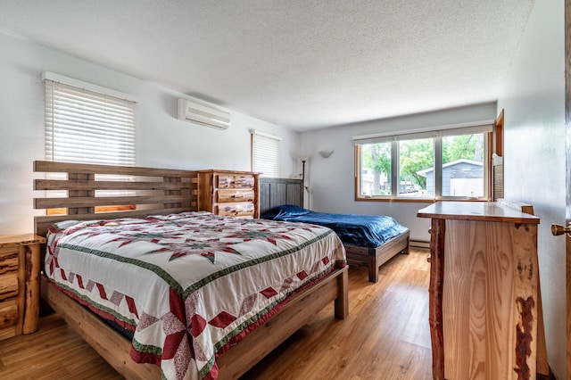 27326 Cloverleaf Ln, Everts Twp, MN 56515 - bedroom with a wall mounted air conditioner, multiple windows, wood finished floors, and a textured ceiling
