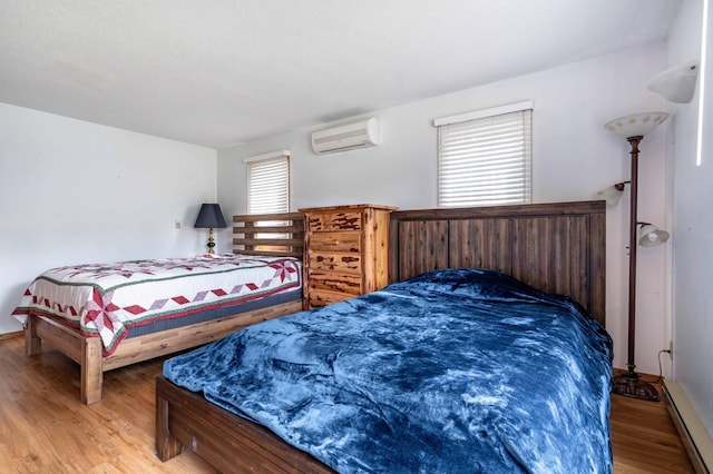 27326 Cloverleaf Ln, Everts Twp, MN 56515 - bedroom featuring a wall mounted air conditioner, wood finished floors, and baseboard heating