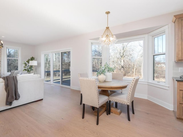 7010 Oak Ridge Rd, Corcoran, MN 55340 - dining area featuring a chandelier, light wood-style floors, and baseboards