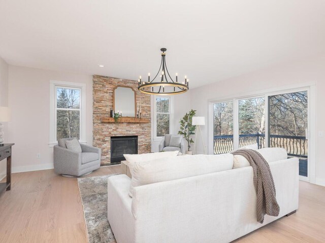 7010 Oak Ridge Rd, Corcoran, MN 55340 - living area with a chandelier, light wood-style flooring, baseboards, a stone fireplace, and recessed lighting