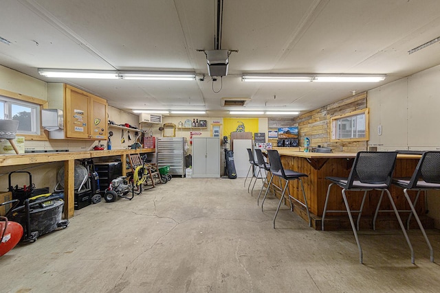 310 Belle St W, Cannon Falls, MN 55009 - garage with a workshop area, a wall mounted air conditioner, and a garage door opener