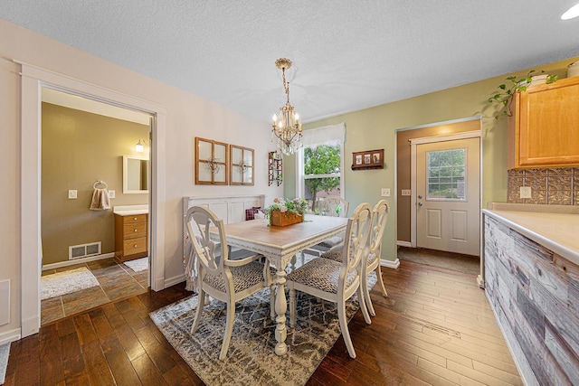 310 Belle St W, Cannon Falls, MN 55009 - dining area with a chandelier, dark wood-type flooring, and a textured ceiling