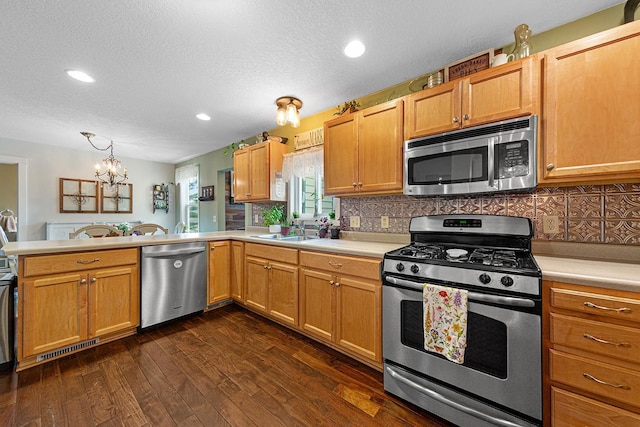 310 Belle St W, Cannon Falls, MN 55009 - kitchen with stainless steel appliances, a peninsula, light countertops, dark wood-style floors, and a textured ceiling