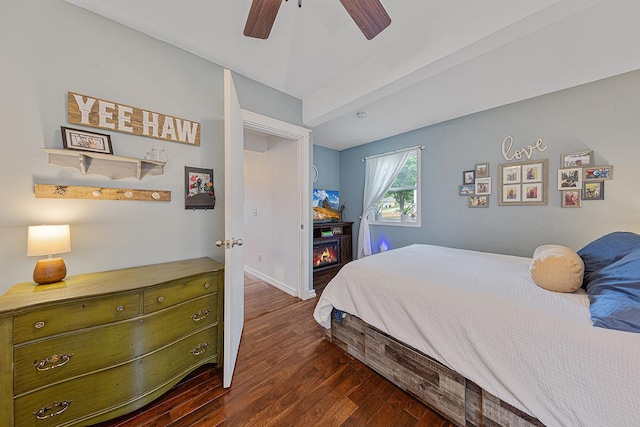 310 Belle St W, Cannon Falls, MN 55009 - bedroom with dark wood-style flooring, a ceiling fan, and a glass covered fireplace