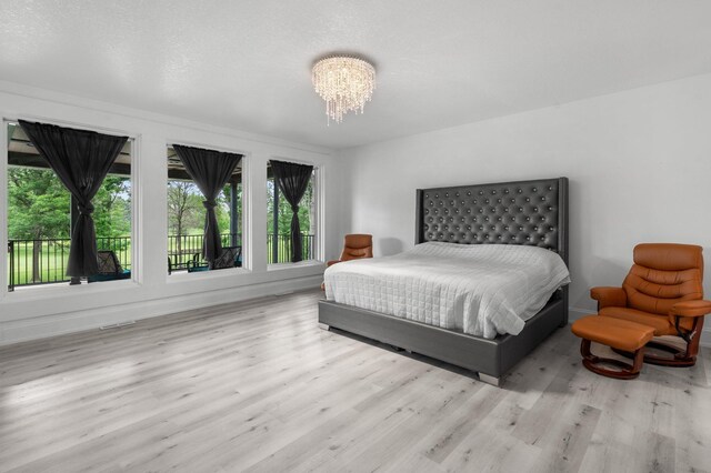 7447 213th St N, Forest Lake, MN 55025 - bedroom with wood finished floors, baseboards, and a chandelier