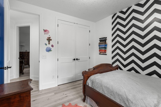 7447 213th St N, Forest Lake, MN 55025 - bedroom with light wood-type flooring, a closet, a textured ceiling, and baseboards