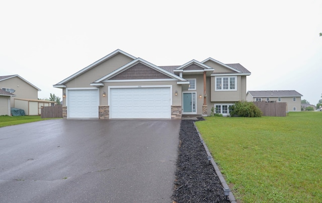 1046 Roosevelt St S, Cambridge, MN 55008 - view of front facade with asphalt driveway, stone siding, and an attached garage