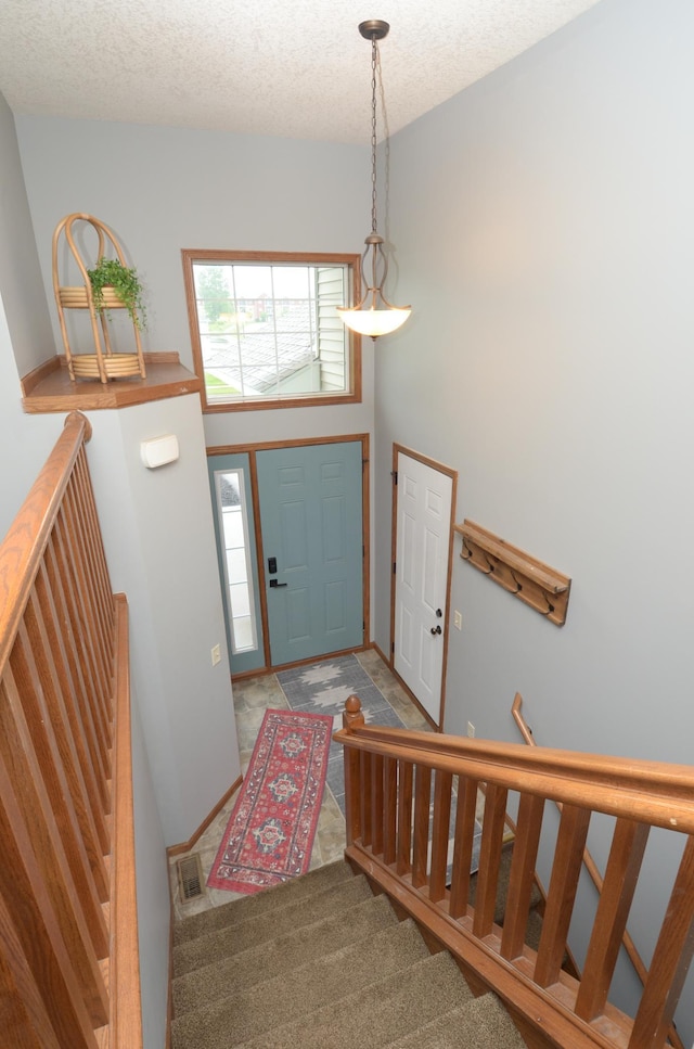 1046 Roosevelt St S, Cambridge, MN 55008 - foyer featuring stairs, a textured ceiling, and carpet floors