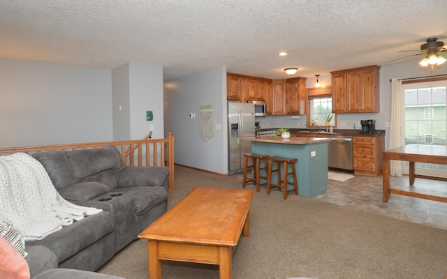 1046 Roosevelt St S, Cambridge, MN 55008 - living area featuring a ceiling fan, a textured ceiling, recessed lighting, and light carpet